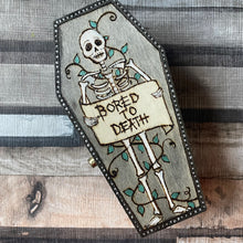 Load image into Gallery viewer, Coffin shaped wooden box with a skeleton holding a sign which reads “Bored to death’ - Pyrography - Woodburning
